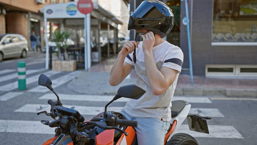 Motocicilista colocando capacete de moto