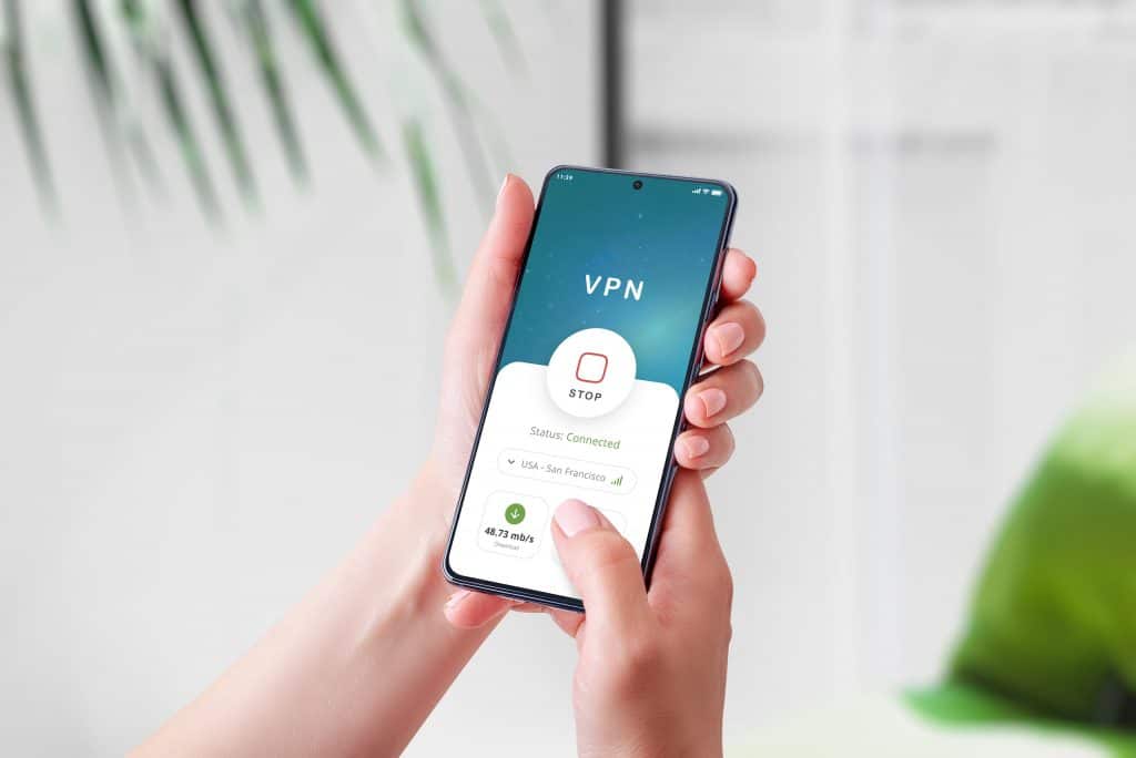 Exemplo de uma VPN exibida em um smartphone, que está nas mãos de uma pessoa