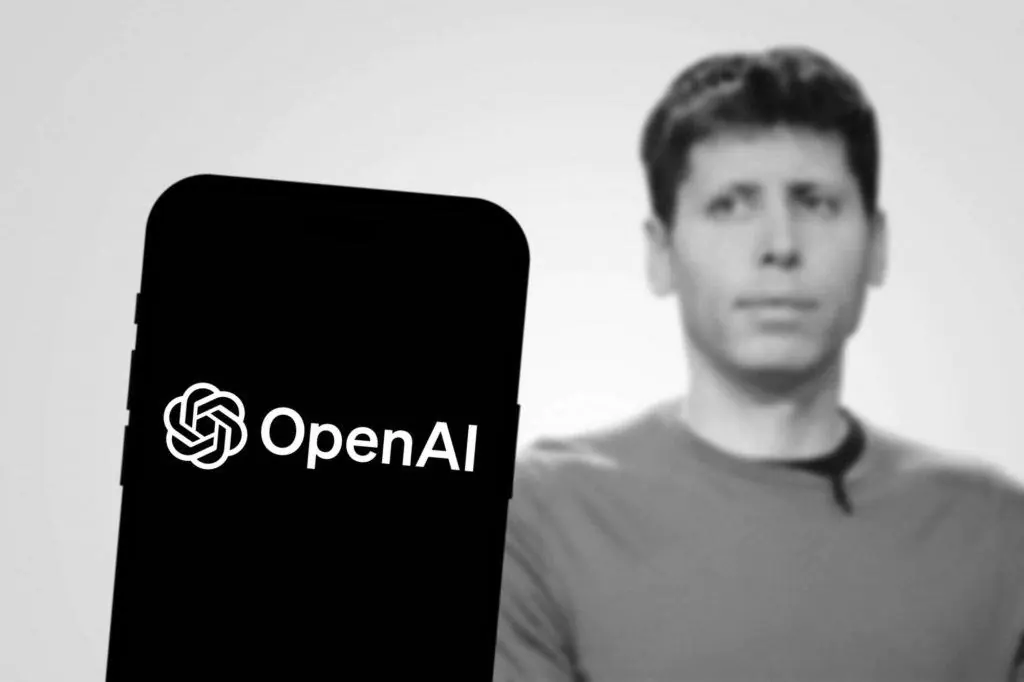 Ao fundo, foto em preto e branco de Sam Altman; à frente, logo da OpenAI em um smartphone